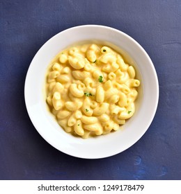 Macaroni And Cheese In White Bowl On Blue Stone Background. Top View, Flat Lay