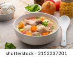 Macaroni Soup with drummet chicken ,tomato ,carrots and onion ,easy asian style clear soup in white bowl