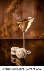 Macarons Champagne-flavored . A Glass Of Champagne. Golden Background 