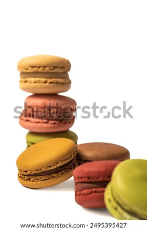 Macarons in a close-up view. The macaron is isolated on a white background, which highlights its vibrant red color and textured surface.