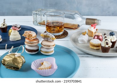 Macarons Stacked Surrounded By Fancy Wedding Sweets, Whiskey Bottle Glass.