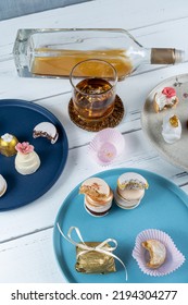 Macarons Stacked Surrounded By Glass And Bottle Of Whiskey And Wedding Candies.