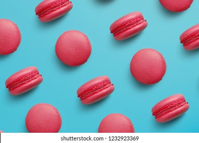 Macaroons on colored background, a pattern of colorful french cookies macarons. Beige, brown french cookies macarons on red background. Gift for Valentine's Day