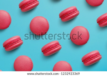 Macaroons on colored background, a pattern of colorful french cookies macarons. Beige, brown french cookies macarons on red background. Gift for Valentine's Day