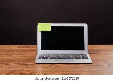 Macbook air laptop and attached sticky note for copy space. Notebook device on wooden desk.
