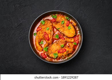 Macher Jhol In Black Bowl On Dark Slate Table Top. Indian Cuisine Bengali Fish Curry. Asian Food And Meal. Top View