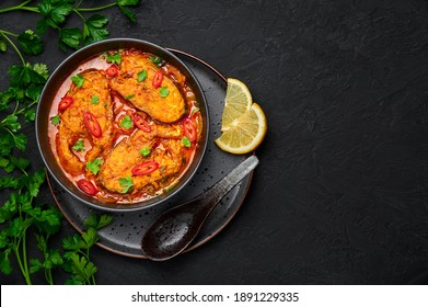 Macher Jhol in black bowl on dark slate table top. Indian cuisine Bengali Fish Curry. Asian food and meal. Top view. Copy space - Shutterstock ID 1891229335