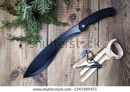 Machete and coniferous branches. Making fire Survival tools. Top view.