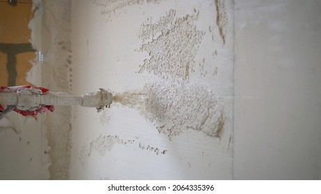 Machine application of mortar to the wall. Machine application of plaster to the wall. Plasterer throws plaster on the wall. Plastering walls in a new house.