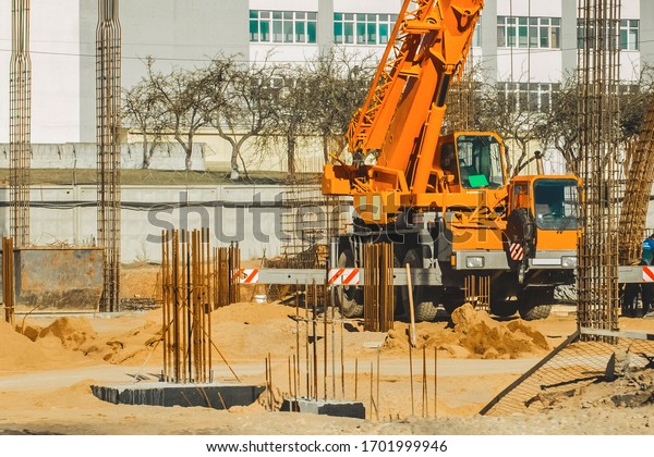 Machine crane, at a construction site,\
concrete structures