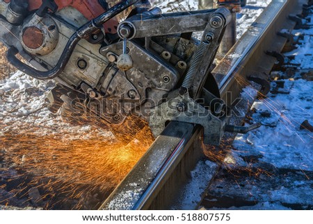 The machine cuts the rail with sparks