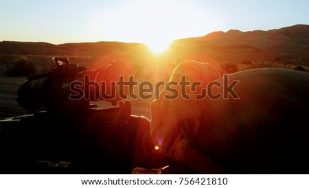 Machine gun and helmet profiled  by mojave desert sunrise.