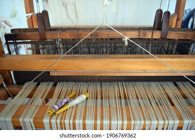The machine is a hand-made wooden loom with threads for working on the machine. An old loom. Denizli. Turkey