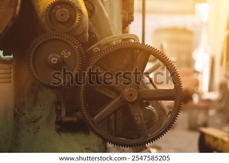 A machine with a large gear that has the number 52 on it. The machine is in a factory setting
