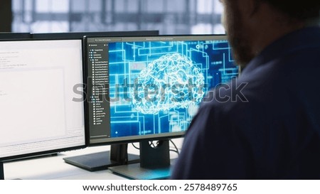 Machine learning expert in AI server room developing disaster recovery plans ensuring minimal downtime. Employee monitoring performance in artificial intelligence ran data center, camera A