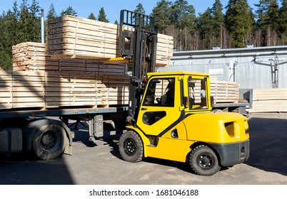 The machine loads the boards, lumber from the finished goods warehouse onto the truck - Shutterstock ID 1681046188