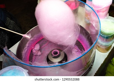 Machine to make cotton candy floss by turning and toasting the pink sugar.