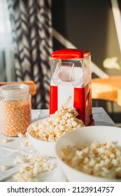 Machine For Making Popcorn At Home Close-up. A Lot Of Ready-made Popcorn In Plates