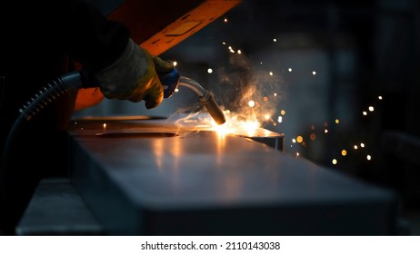 Machine manufacturing in the workshop. Metal joining by welding. Source light and effect. Skilled worker using welding machine. - Shutterstock ID 2110143038
