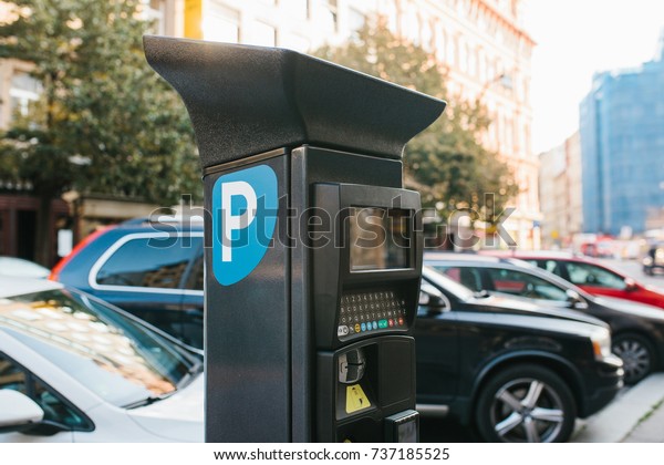 Machine for paying parking.\
Close-up - machine for paying parking on background of blurry\
cars