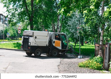 Machine sweeper - cleaner cleans the roadway. Machine brushes sweeping the street. The car vacuumed on the street. Municipal equipment. - Shutterstock ID 775264492
