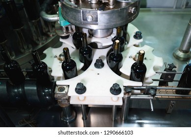 machine that putting cap in wine bottles at factory