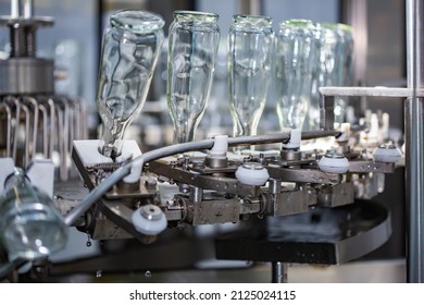 The machine for washing glass bottles. Factory for bottling alcoholic beverages. - Shutterstock ID 2125024115