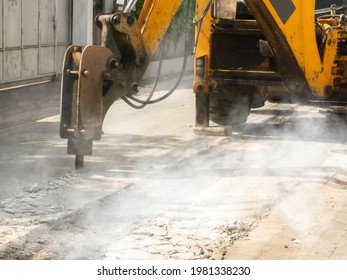 Machine is working to drill the concrete pavement Causing dust smoke and noise pollution The operation of the machine to drill the road surface