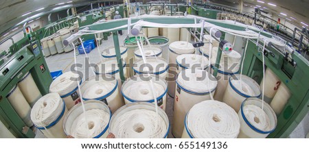 Machinery and equipment in a spinning production company.Automated robotic factories, lined with neat spinning machines. Background of modern textile industry.
