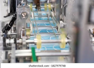 Machines Are Working For Producing Masks In A Sterile Factory. Production Of Medical Masks. Process Of Manufacturing A Mask