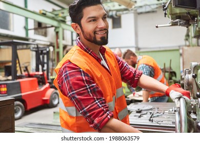 Machinist In The Workshop Of The Metal Factory Operates A Wheel On A Drill Press