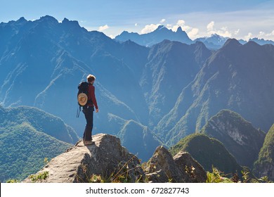 Machu Picchu, Peru - April 22, 2017. Man Walking On Mountain Peak On Bright Sunny Day