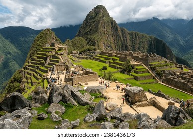 Machu Picchu ruins with tourists with dramatic clouds, Machu Picchu historical Sanctuary, Cusco, Peru. - Powered by Shutterstock