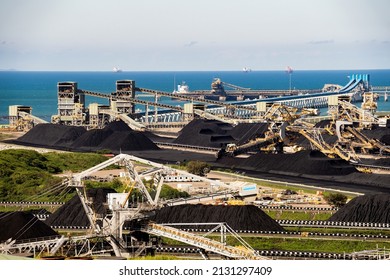 Mackay, Queensland, Australia - February 2022; Hay Point coal loading facility with  conveyors, wharves, stacker reclaimers and stockpiles of coal ready to ship.