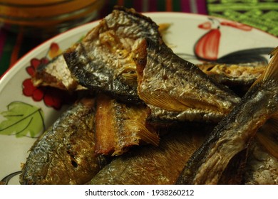 Mackerel fishes and sea fishes fried on the white floral ceramic plate. 