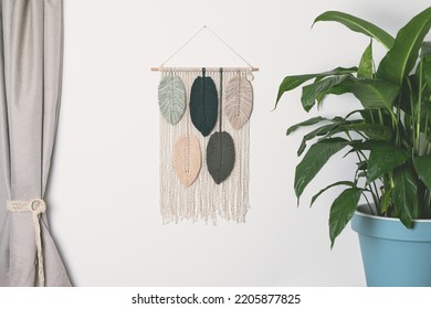 macrame handmade artistic wall hanging fiber art decoration with leaf feather symbols wood stick white background interior plant macramé nature deco with green forest olive frappe beige colors - Shutterstock ID 2205877825