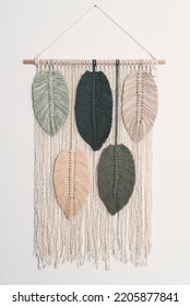 macrame handmade artistic wall hanging fiber art decoration with leaf feather symbols wood stick white background interior plant macramé nature deco with green forest olive frappe beige colors - Shutterstock ID 2205877841