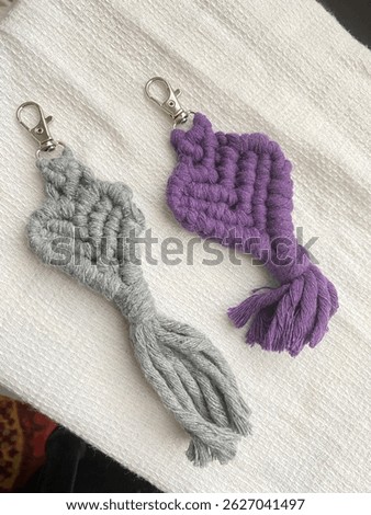 Macrame keychain made of cotton thread. Handcrafted work. Decoration Artworks. Handicrafts. Macrame art for gift. Keychain isolated on a white background. Handmade.