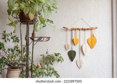 Macrame leaves wall hanging in yellow, white, green and natural color on the wooden stick. Cotton rope decor macrame to make your room more cozy and unique. Close up - Shutterstock ID 2221897503