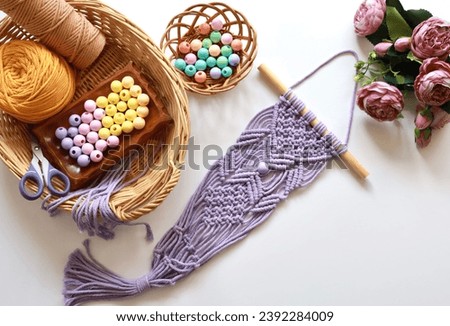 

Macrame wall hanging for home decoration, creative hobby layout with accessories, top view