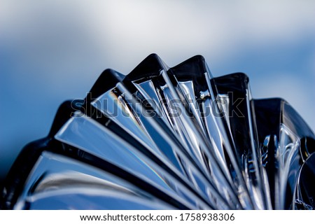 Macro abstract art texture view of sparkling lead crystal glass texture with scallop pattern, reflecting sky blue color