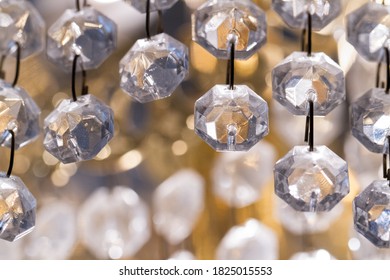 Macro abstract closeup of string of plastic diamond jewel beads in a home chandelier	interior dining room decorative lighting fixture
