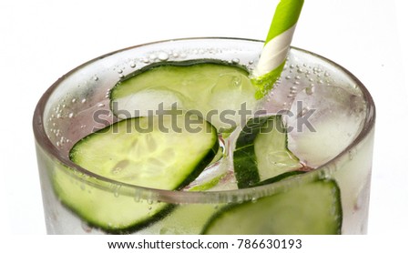 Macro of bubbling drink - gin and tonic with cucumber and straw