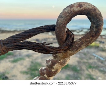 Macro Of A Cable Made Up Of Several Rusty Steel Wires, Some Of Which Are Broken, Hooked To A Wrought Iron Ring