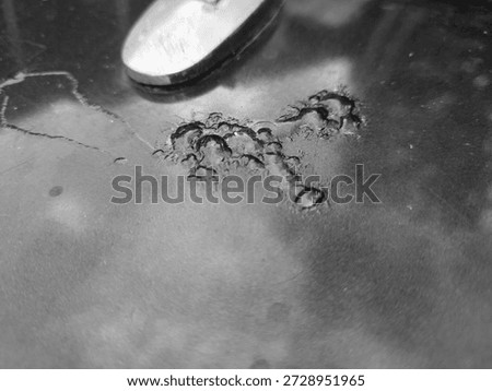 Macro of car paint bubbling and corroding on a metal surface in black and white. Authentic monochrome texture of vehicle rust for automotive repair.