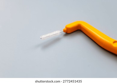 A macro close up of an angle interdental brush isolated on grey.
