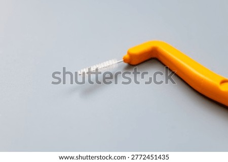 A macro close up of an angle interdental brush isolated on grey.