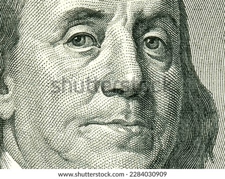 Macro close up of Ben Franklin's face on the US $100 dollar bill.