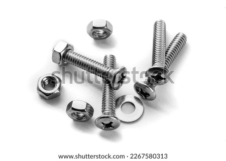 a macro close up of cross type pan head machine screws and nuts and a flat washer isolated on white