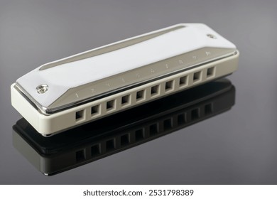 Macro close up of diatonic harmonica lying on reflective plastic sheet